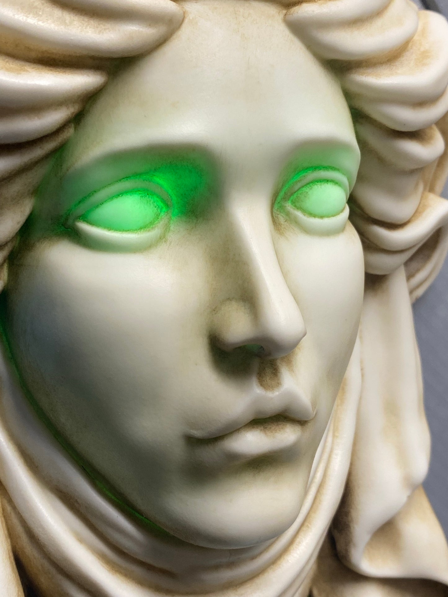 Madame Leota stone plaque with green led eyes.